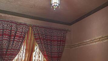 A traditional room with a patterned sofa, a small round table, and a decorative ceiling light.