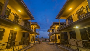 A courtyard with a paved walkway surrounded by buildings with balconies and railings. - Victoria Breeze Hotel Apartment (Iganga)