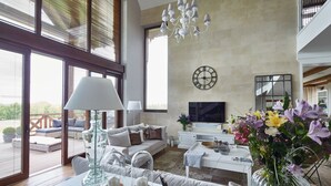 A spacious living room with a sofa, coffee table, and a large window. - Siedlisko 518 Wzgorza Dylewskie (Ostróda)