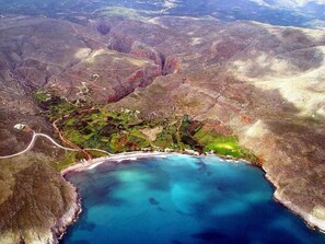 An aerial view of a coastal area with a small settlement, roads, and a clear blue bay. - Alkioni Sea View (Sitia)