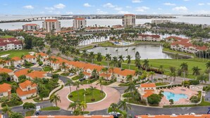A resort with multiple buildings, a central pool, and a marina.