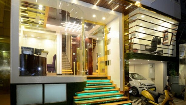 Un edificio moderno con fachada de vidrio, una escalera con peldaños iluminados y un scooter estacionado.