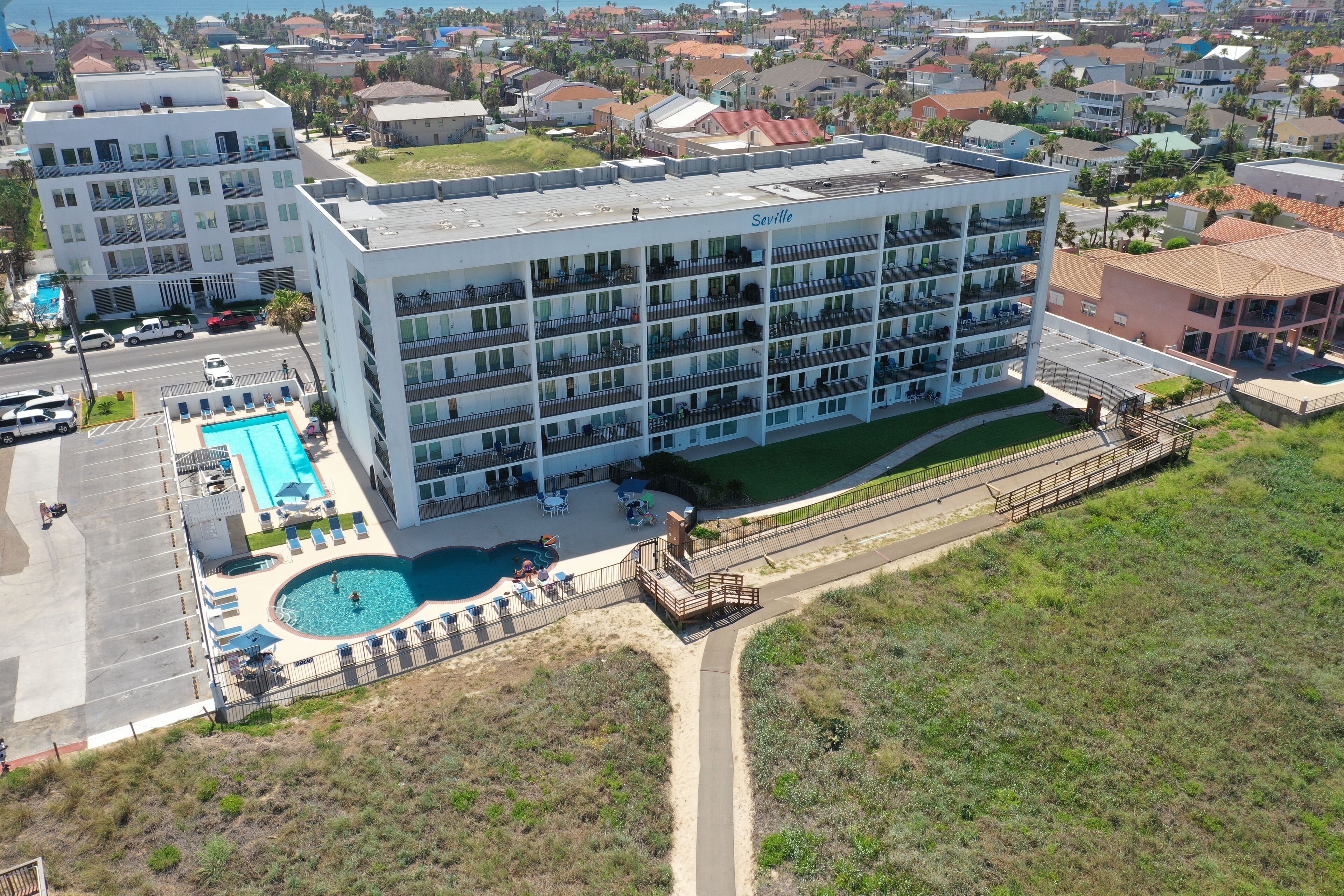 Un hôtel à plusieurs étages doté d’une piscine, d’un espace extérieur aménagé et offrant une vue sur le quartier environnant.