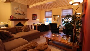 A cozy living room with a brown sofa, a wooden coffee table, and a dining area with a table and chairs.