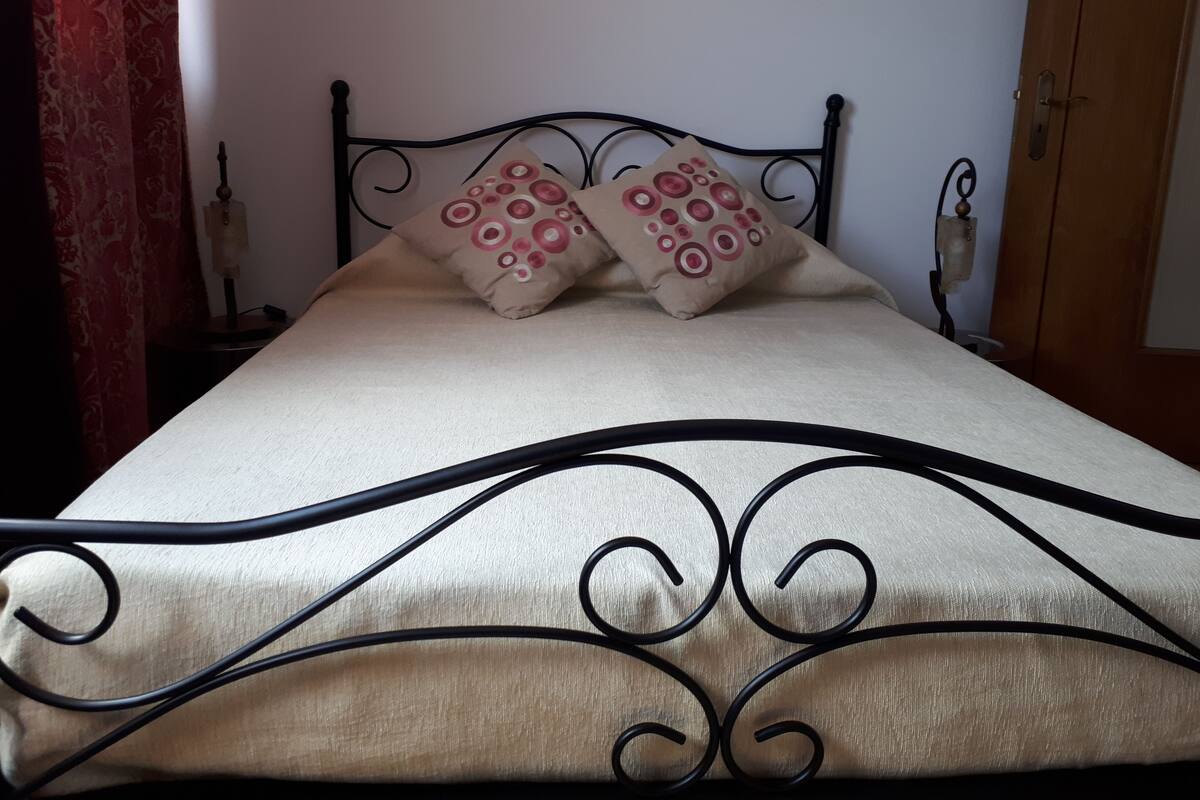 A bed with a metal frame and two pillows with circular patterns.