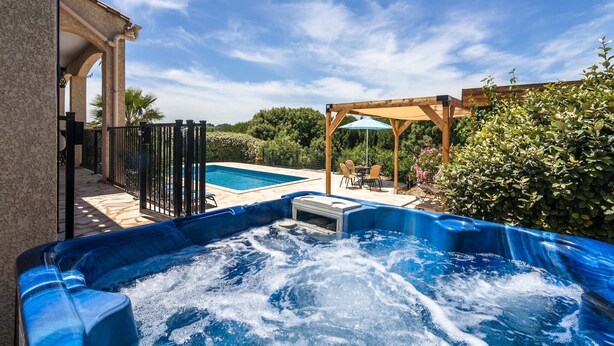 Ein Bereich mit Whirlpool, Pool, Sitzgelegenheiten im Freien und einer Pergola.