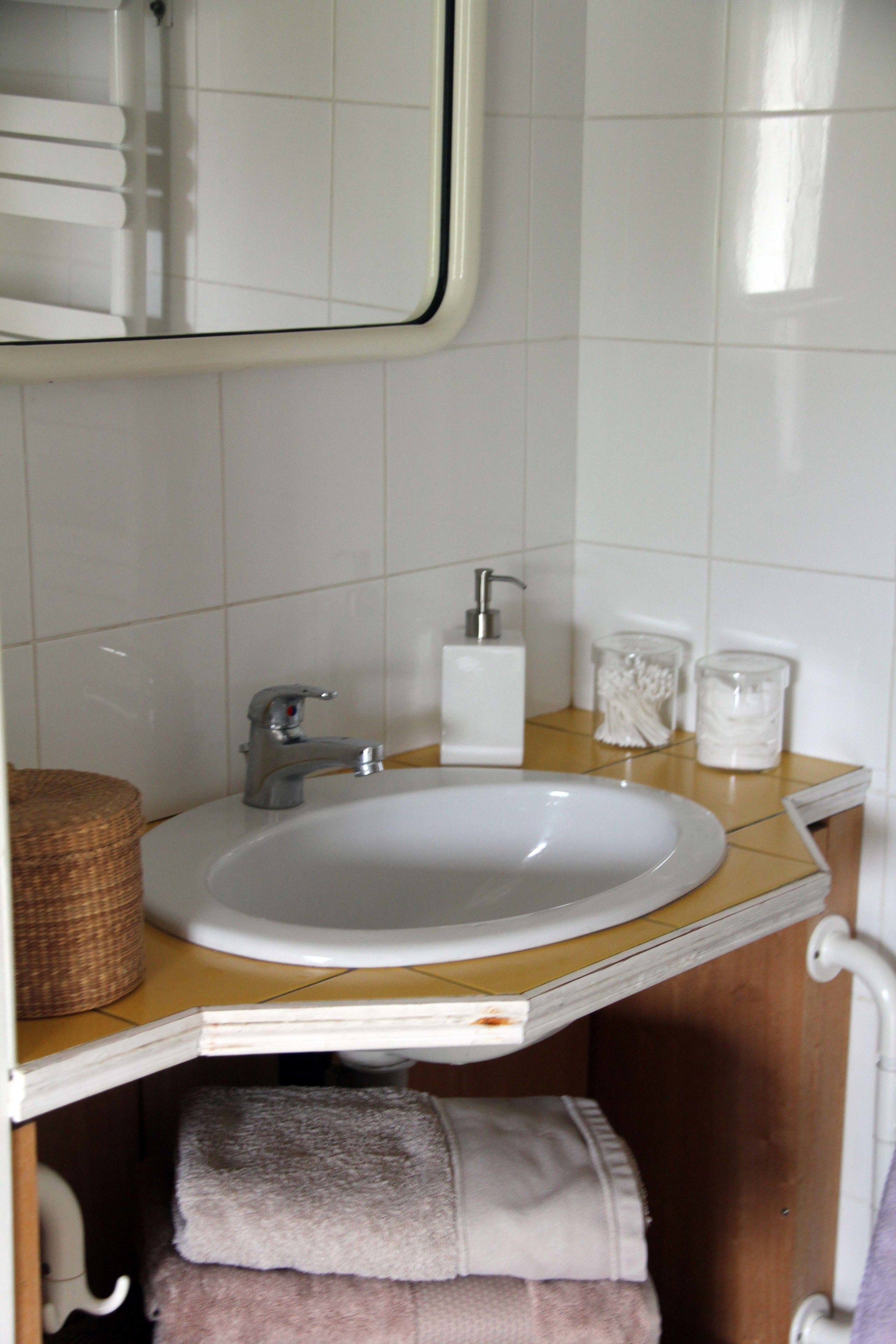 A bathroom with a white sink, a mirror, and a towel rack.