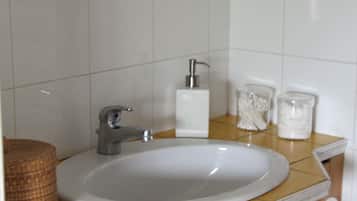 A bathroom with a white sink, a mirror, and a towel rack.
