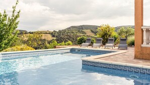 A swimming pool with lounge chairs, surrounded by greenery and hills in the background. - Hillside Retreat in Roquebrun (Roquebrun)