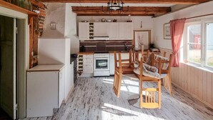 A compact kitchen with white cabinets, a built-in oven, and a dining area with wooden chairs and a table. - Gorgeous home in Vinslöv with WiFi (Vinslöv)