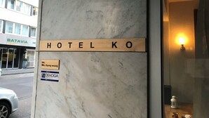 Un letrero de hotel con la inscripción 'HOTEL KO' sobre una pared de mármol.