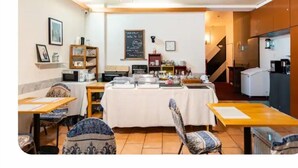 Un comedor con mesas de buffet, un refrigerador y un menú escrito en una pizarra.