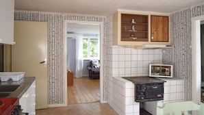 A kitchen with a stove, cabinets, and a view into another room. - 2 bedroom nice home in åsenhöga (Åsenhöga)