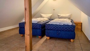 A small, cozy attic bedroom with two beds, wooden beams, and a sloped ceiling. - Vacation apartment Ostseestern 19O-2 bedrooms up to max. 4 pers. + 2 baby - Holiday home (Trassenheide)