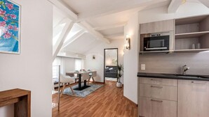 A modern kitchen with wooden cabinets, a built-in oven, and a black countertop. - Romantik Hotel Stern (Chur)