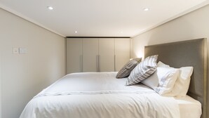 Ein Schlafzimmer mit einem großen Bett, einer Kopfteil und einem Kleiderschrank.