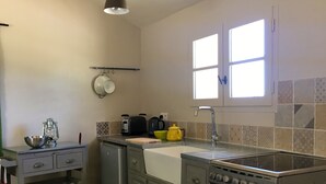 Una cocina funcional con lavamanos, estufa y una pequeña encimera.