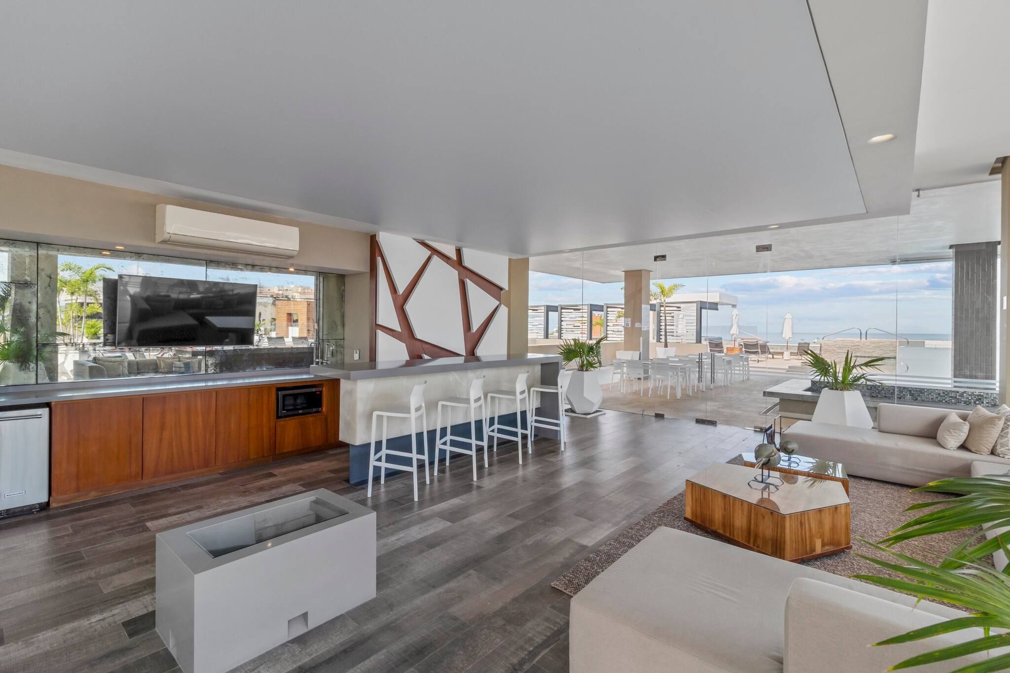 A modern living space with a kitchen, dining area, and seating area with a view.