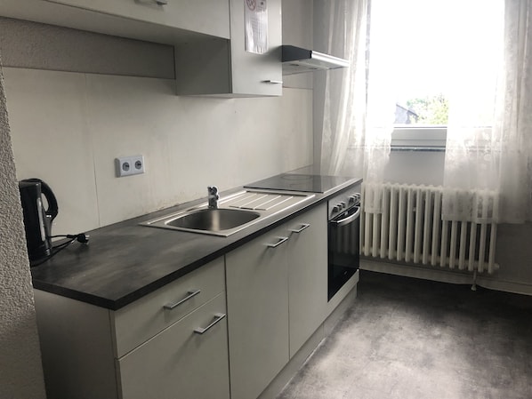 Kjøleskap på fellesområdet, mikrobølgeovn, kokeplater og kjøkkenutstyr