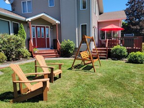 Enjoy a serene outdoor space with a lawn, swing set, and a cozy porch area.