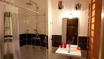 A bathroom with a shower, a sink, and a mirror.