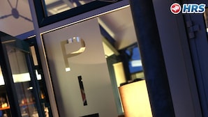 A glass door with the inscription "PIER 19 by TKIJK" and a small potted plant beside it. - Hotel Utkiek (Greifswald)