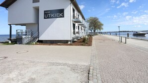 A modern building with a sign reading "Hotel UTKIEK" by the water. - Hotel Utkiek (Greifswald)