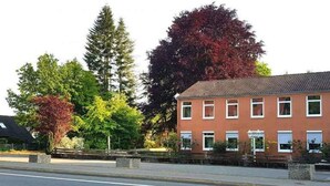 A red brick building with multiple windows and a sign for 'Pension Highway.' - Pension Highway 3 Sennestadt-Bielefeld (Bielefeld)