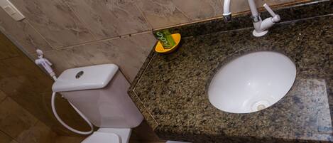 Un baño con inodoro, lavabo y ducha.