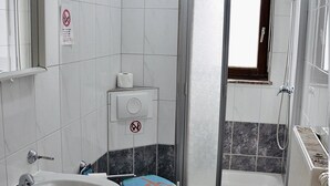 A bathroom with a sink, toilet, and shower. - Pension Highway Bünde (Buende)