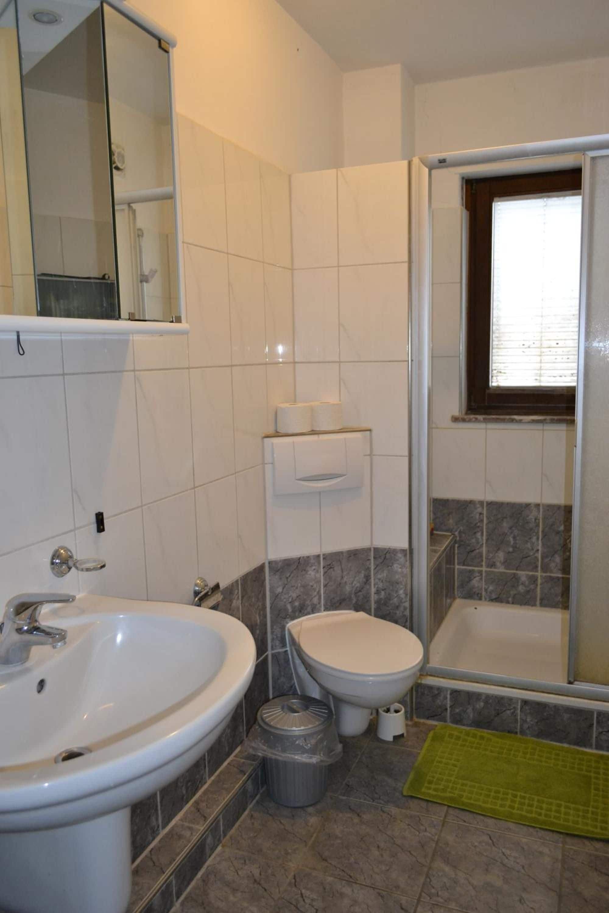 Ein Badezimmer mit Waschbecken, Toilette und Dusche.