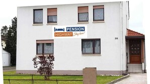 A building with a sign that reads 'Pension Highway Stay here!' and the number 39. - Pension Highway Bünde (Buende)