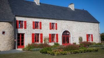 Traditional stone building with a steeply pitched roof and central arched window.