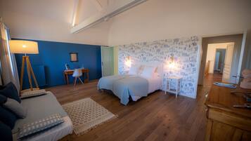 A bedroom with a bed, bedside tables, a desk, and a lamp.