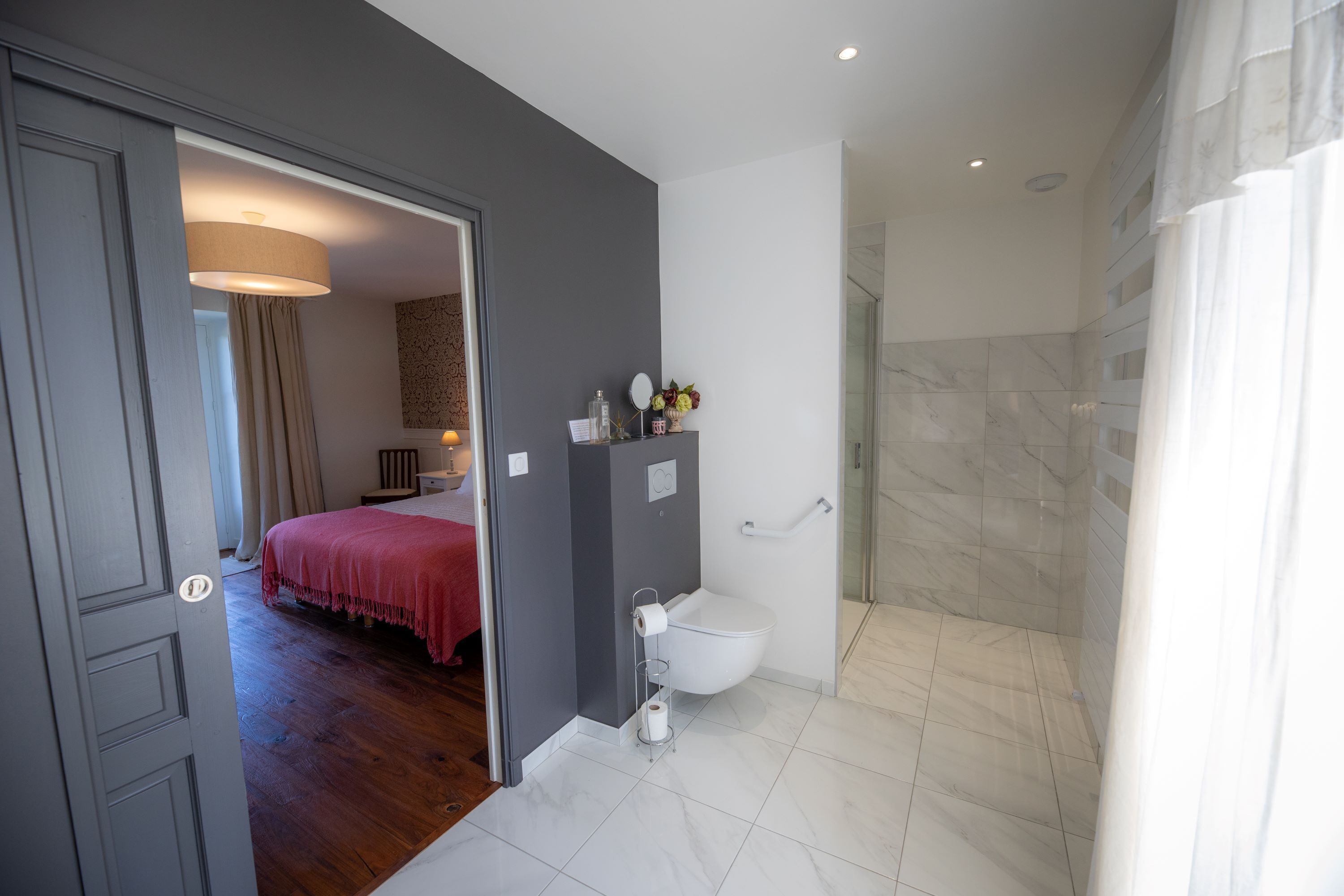 Une salle de bain moderne équipée de toilettes, d’un lavabo et d’une zone douche.