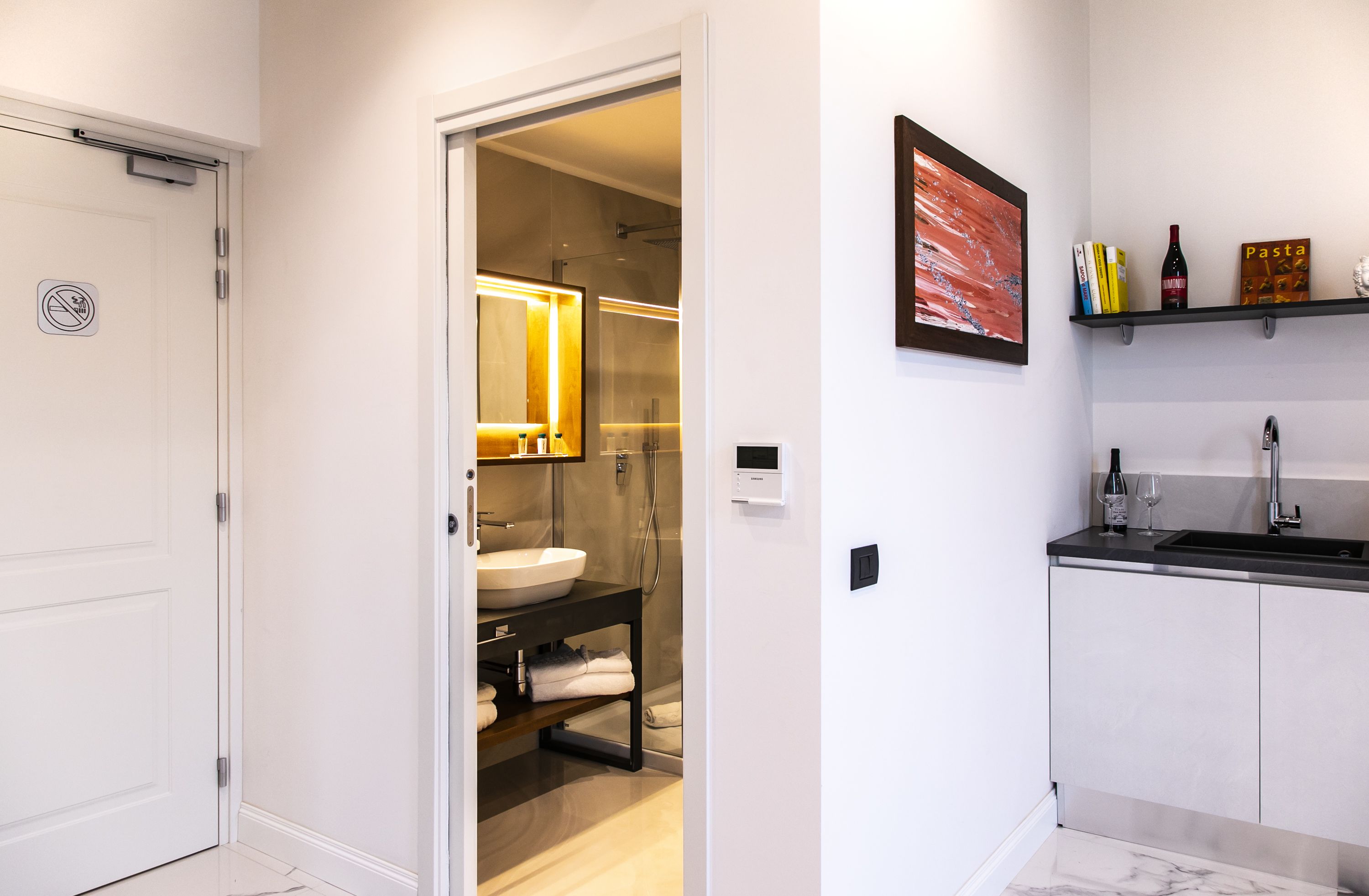 A modern bathroom with a white sink, a mirror, and a towel rack.