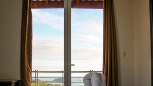 A room with a large window, a bed, and a view of a landscape. - Villa Manuel Antonio for 8 people (Quepos)
