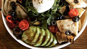 Une assiette contenant divers légumes, un œuf poché et du poulet grillé.