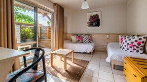 Ein gemütliches Zimmer mit einem Bett, einem kleinen Tisch, einem Stuhl und einem Fenster mit Vorhängen.