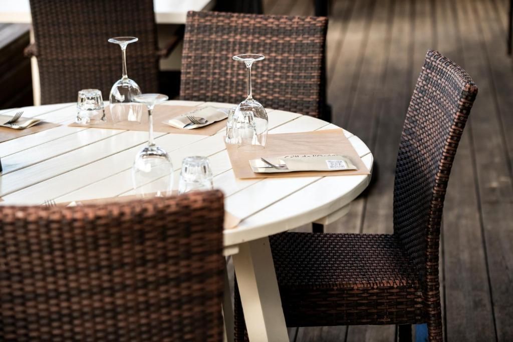 A round dining table with chairs, clear glassware, and a menu.