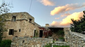 A rustic stone building with a stone wall and steps leading to a door. - Bendeni Cottage (Chania)