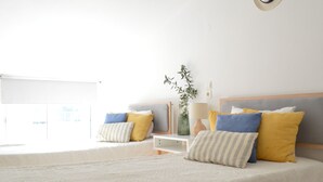 A bedroom with two beds, a bedside table, a lamp, and a plant. - Akti Posidonos (Agios Nikolaos)
