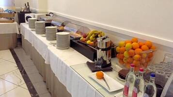Un buffet con piatti, frutta e bevande.