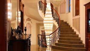 A grand staircase with a crystal chandelier, marble flooring, and ornate railings. - Suter Palace Heritage Boutique Hotel (Bucharest)