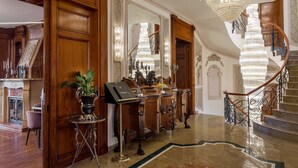 A grand lobby with a marble floor, a grand staircase, and a chandelier. - Suter Palace Heritage Boutique Hotel (Bucharest)