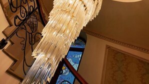 A grand staircase with a crystal chandelier and ornate metal railings. - Suter Palace Heritage Boutique Hotel (Bucharest)