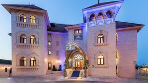 A large, multi-story hotel with a grand entrance, multiple balconies, and illuminated architectural details. - Suter Palace Heritage Boutique Hotel (Bucharest)