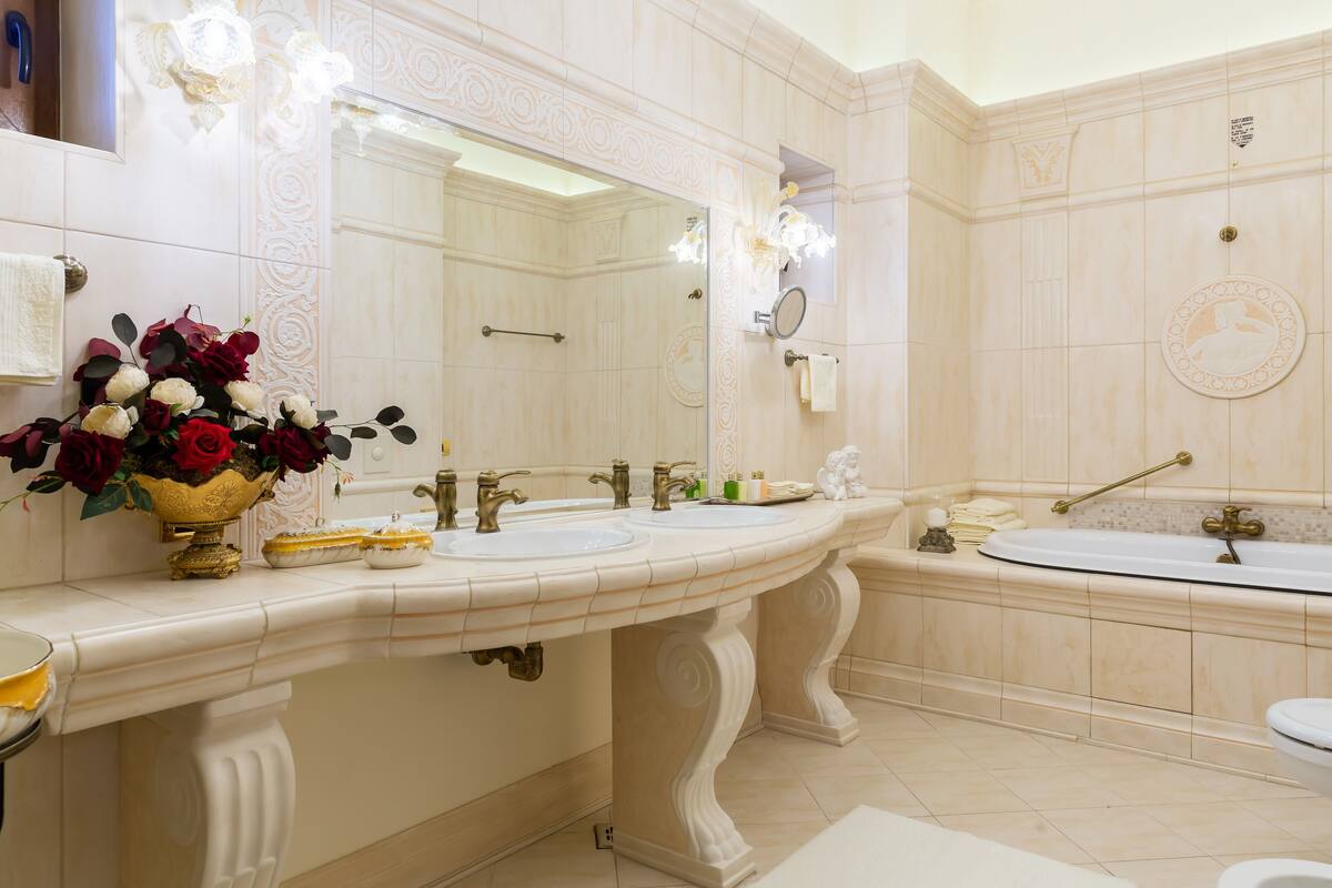 A luxurious bathroom with two sinks, a large mirror, and a bathtub.
