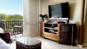 Un balcone con una televisione, libri e una pianta.