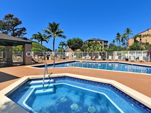 Area piscina con idromassaggio, sedie a sdraio e zona relax coperta.